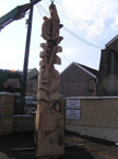 The finished carving is being lifted into position with a crane