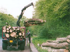 Rear view of the AC Matador, lifting several large tree segments, the cargo area almost at capacity