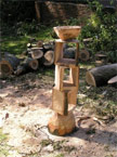 A lkarge roughly 14 inches square stand composed of 3 hollow boxes with a bowl on the top, photographed from the front