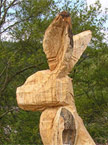 Another roughed out more weathered rabbit sits amidst a logpile