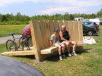 Large sleeper benches designed so that bikes can be parked around the back while the cyclists sit around the front and get some 