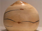 Vase with horizontal cracks filled with blue substance, photo taken from the side