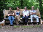 Large park style bench made from a split fork, and halved tree trunk